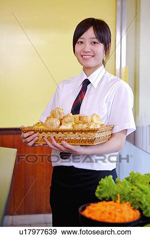 Young waitress holding food and smiling at the camera, Restaurant View Large Photo Image Stock Photo - Young waitress holding food and smiling at the camera, Restaurant. Fotosearch