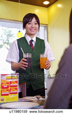 Young waitress serving drink for the customer, Restaurant View Large Photo Image Stock Photo - Young waitress serving drink for the customer, Restaurant. Fotosearch