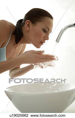 Young woman splashing water on her face View Large Photo Image Stock Image - Young woman splashing water on her face. Fotosearch