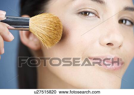 A young woman applying blusher with a brush View Large Photo Image Stock Image - A young woman applying blusher with a brush. Fotosearch
