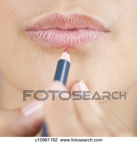 A young woman applying lip liner View Large Photo Image Stock Image - A young woman applying lip liner. Fotosearch