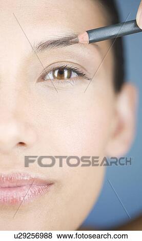 A young woman using an eyebrow pencil View Large Photo Image Stock Photo - A young woman using an eyebrow pencil. Fotosearch
