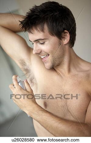 Young man applying de-odorant/anti-perspirant View Large Photo Image Stock Image - Young man applying de-odorant/anti-perspirant. Fotosearch