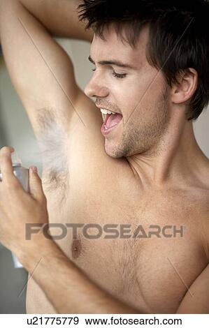 Young man applying de-odorant/anti-perspirant View Large Photo Image Stock Photo - Young man applying de-odorant/anti-perspirant. Fotosearch