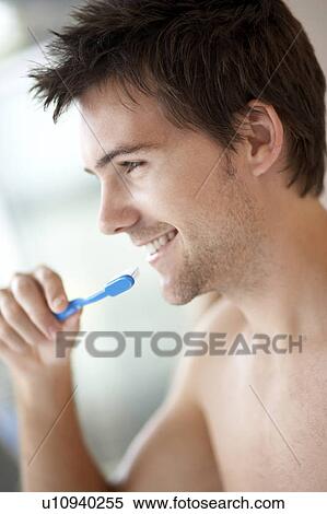 Stock Photography - Young man brushing his teeth, close-up. Fotosearch