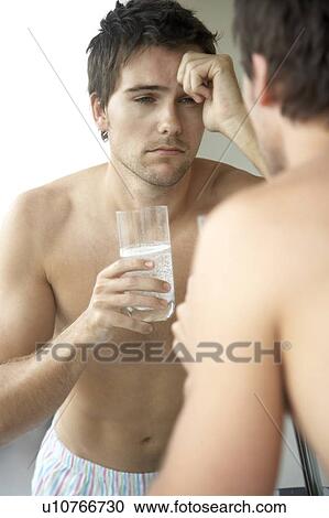 Young man drinking a hangover remedy View Large Photo Image Stock Image - Young man drinking a hangover remedy. Fotosearch