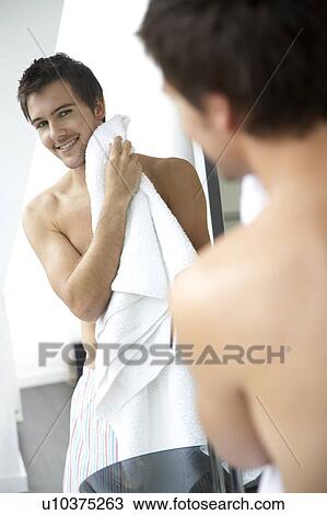 Young man drying his face with a towel View Large Photo Image Stock Image - Young man drying his face with a towel. Fotosearch