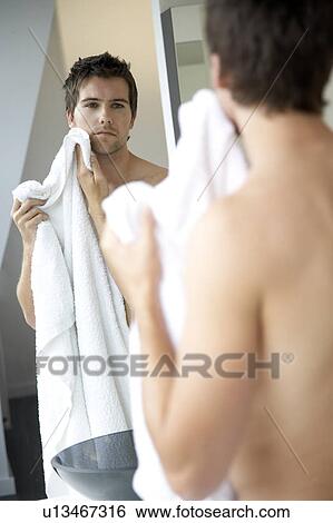 Young man drying his face with a towel View Large Photo Image Stock Photograph - Young man drying his face with a towel. Fotosearch