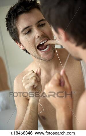 Young man flossing his teeth View Large Photo Image Stock Photograph - Young man flossing his teeth. Fotosearch