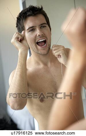 Stock Photography - Young man flossing his teeth. Fotosearch