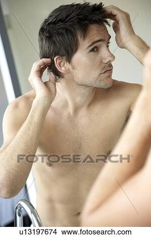 Young man styling his hair View Large Photo Image Picture - Young man styling his hair. Fotosearch