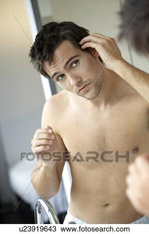 Young man styling his hair View Large Photo Image Stock Image - Young man styling his hair. Fotosearch