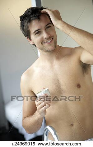Stock Photography - Young man styling his hair. Fotosearch