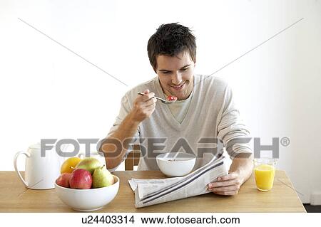 Young man having breakfast View Large Photo Image Picture - Young man having breakfast. Fotosearch