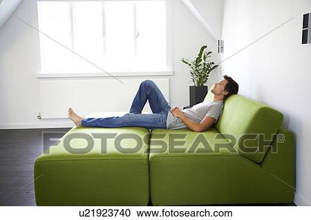 Young man laying on a bed View Large Photo Image Stock Image - Young man laying on a bed. Fotosearch