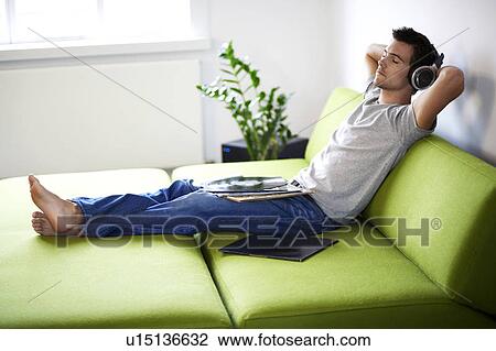 Young man listening to music View Large Photo Image Stock Image - Young man listening to music. Fotosearch