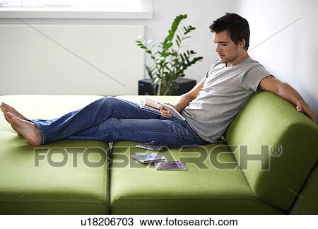 Young man looking at his CD collection View Large Photo Image Stock Image - Young man looking at his CD collection. Fotosearch
