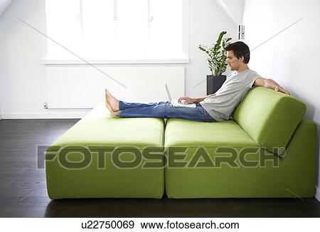 Young man sitting in a bedroom View Large Photo Image Stock Photo - Young man sitting in a bedroom. Fotosearch