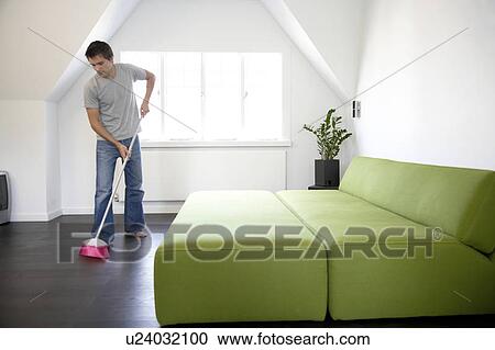 Young man sweeping the floor View Large Photo Image Stock Image - Young man sweeping the floor. Fotosearch