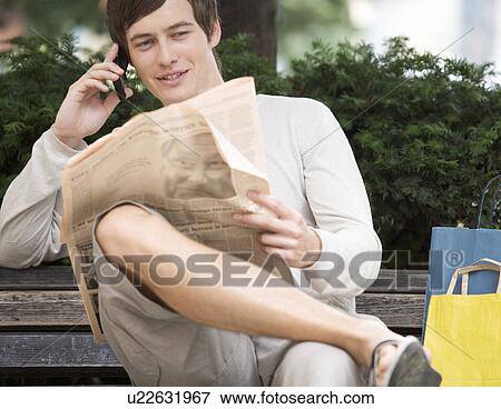Stock Photo - A young man having a break whilst out shopping. Fotosearch