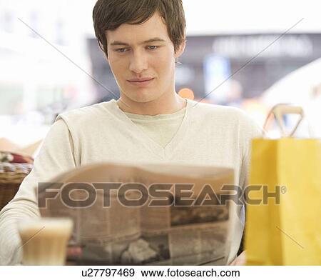 A young man having a break whilst out shopping View Large Photo Image Stock Photo - A young man having a break whilst out shopping. Fotosearch