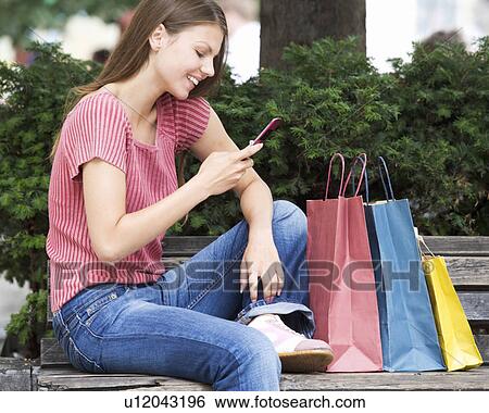 A young woman having a break from shopping View Large Photo Image Stock Photograph - A young woman having a break from shopping. Fotosearch
