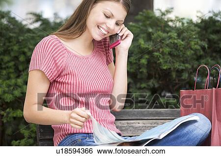 Stock Photograph - A young woman having a break from shopping. Fotosearch