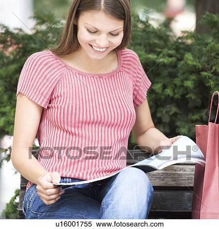 Stock Photography - A young woman having a break from shopping. Fotosearch