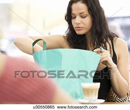 Stock Photography - A young woman looking at her purchases. Fotosearch