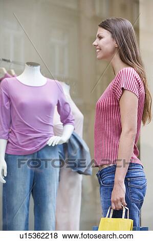 A young woman looking in a shop window View Large Photo Image Stock Photo - A young woman looking in a shop window. Fotosearch