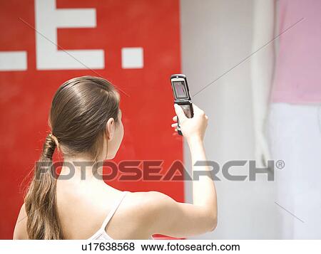 A young woman looking in a shop window View Large Photo Image Stock Photo - A young woman looking in a shop window. Fotosearch