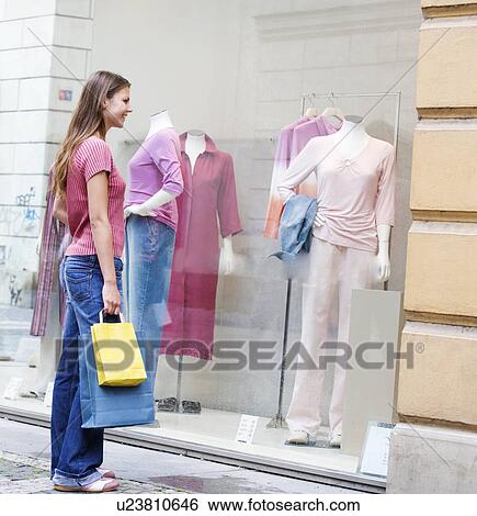 Stock Photograph - A young woman looking in a shop window. Fotosearch