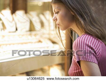 Stock Photography - A young woman looking in a shop window. Fotosearch