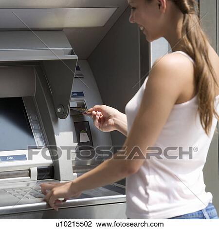 A young woman using a cash machine View Large Photo Image Stock Image - A young woman using a cash machine. Fotosearch