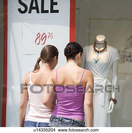 Two young women looking in a shop window View Large Photo Image Picture - Two young women looking in a shop window. Fotosearch