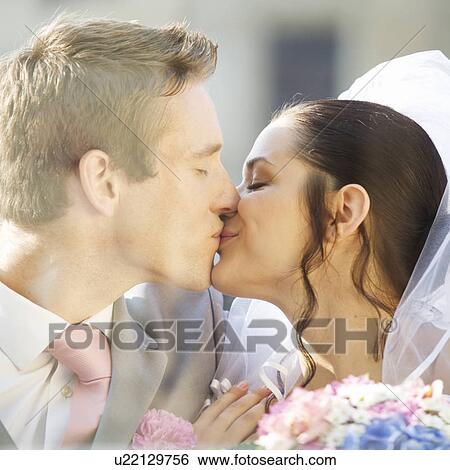 Stock Photograph - A bride and groom kissing. Fotosearch