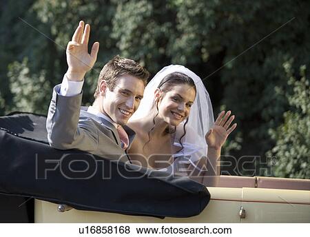 Stock Photo - A bride and groom sitting in the wedding car. Fotosearch