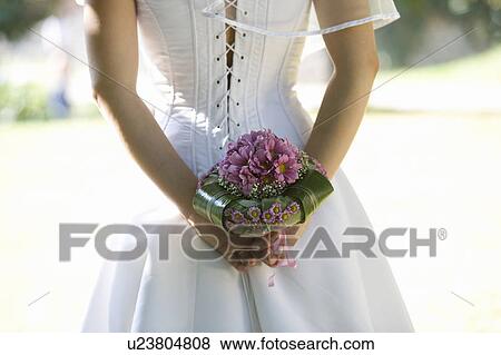 Stock Photo - A bride holding a bouquet. Fotosearch