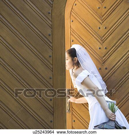 A bride looking through the church doors View Large Photo Image Picture - A bride looking through the church doors. Fotosearch