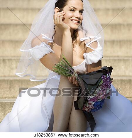 Stock Photo - A bride sitting outside the church. Fotosearch