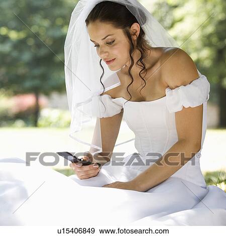 Stock Photo - A bride using a mobile phone. Fotosearch