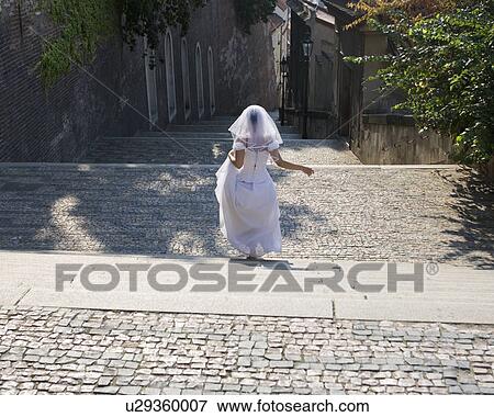 Stock Photo - A bride walking down steps. Fotosearch