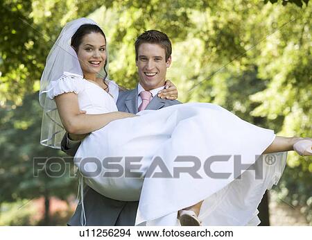 Picture - A groom carrying his bride. Fotosearch