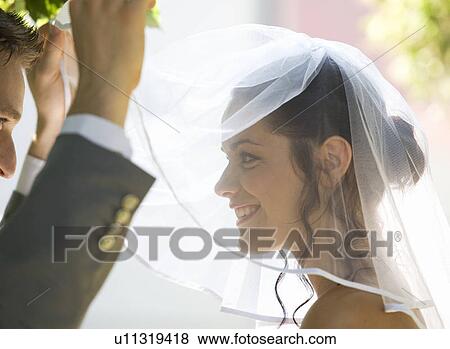 A groom lifting the veil of his bride View Large Photo Image Stock Photo - A groom lifting the veil of his bride. Fotosearch