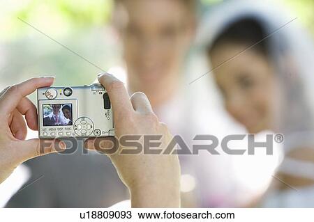 A guest taking a photo of the bride and groom View Large Photo Image Stock Image - A guest taking a photo of the bride and groom. Fotosearch