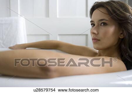 Picture - A young woman laying in a bath. Fotosearch