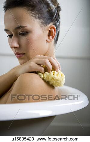 A young woman laying in a bath View Large Photo Image Stock Image - A young woman laying in a bath. Fotosearch