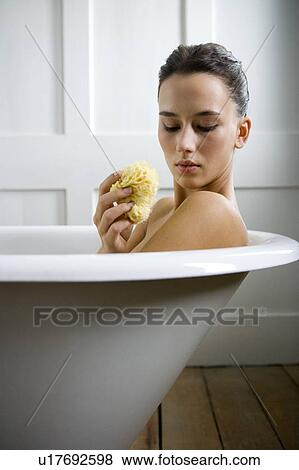 Stock Photo - A young woman laying in a bath. Fotosearch