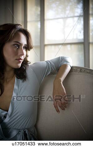 Stock Image - A young woman wearing silk pyjamas. Fotosearch