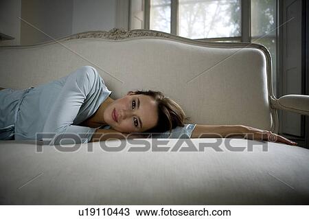 Stock Image - A young woman wearing silk pyjamas. Fotosearch